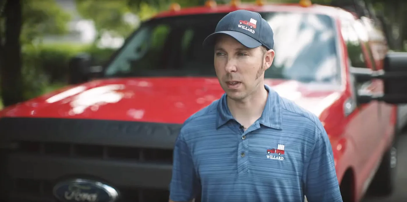 Daniel Busby, President of Willard Power Vac, beside a company truck
